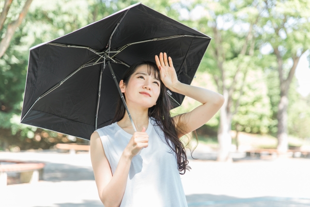 黒い日傘をさす女性